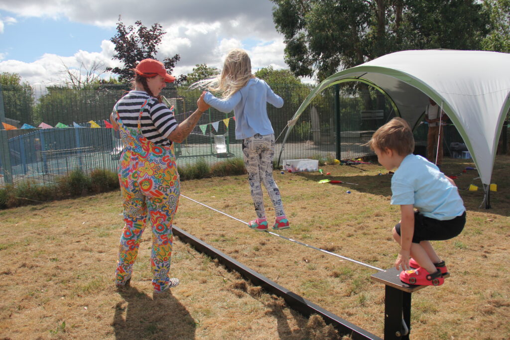 children are helped to balance on a tightrope